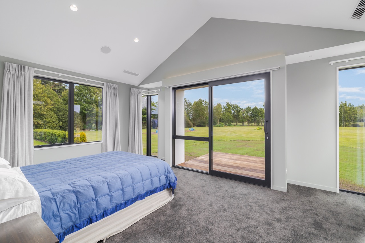 Master bedroom with sliding door to deck and rural views