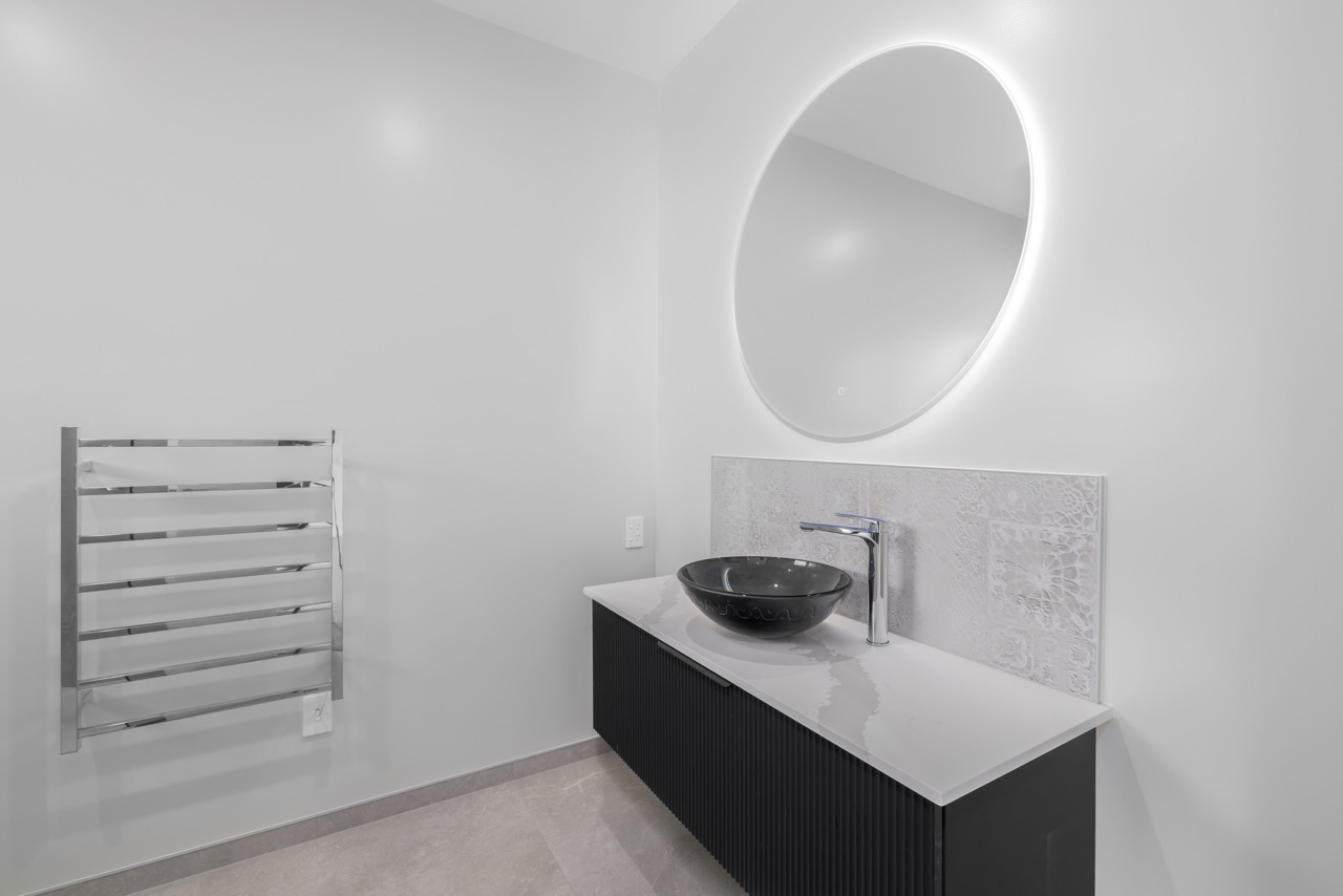 Powder room with floating vanity, vessel basin, and LED mirror