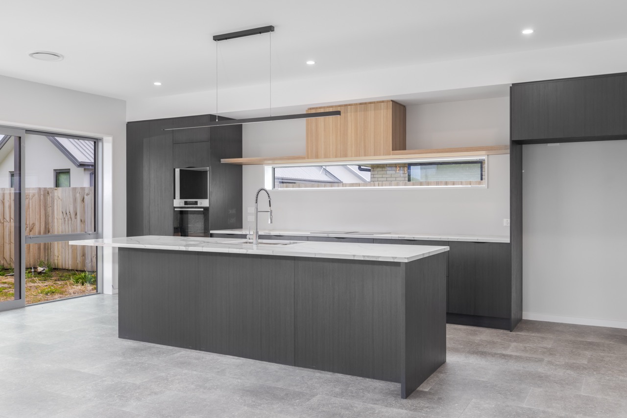 Dark kitchen with island bench and timber accents