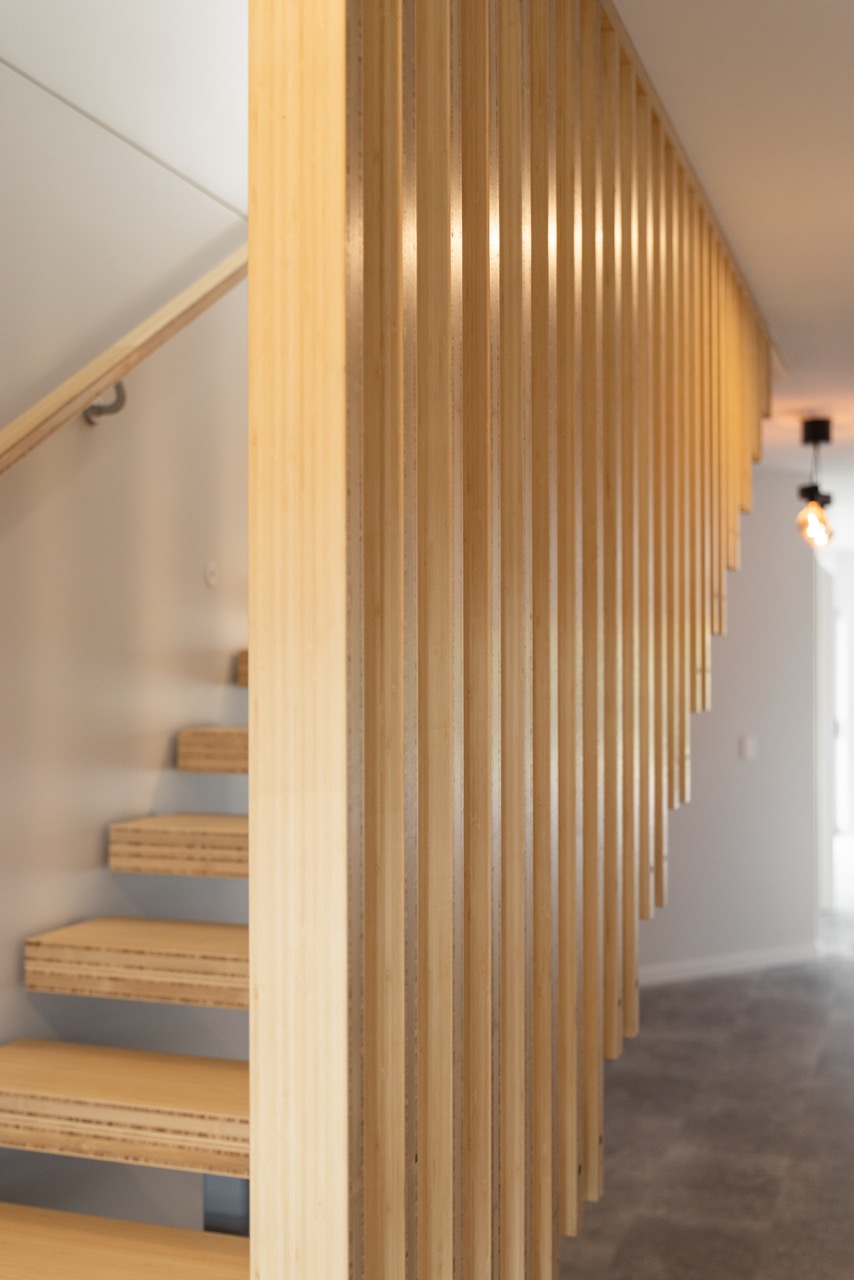 Close-up of timber batten staircase screen with pendant lighting