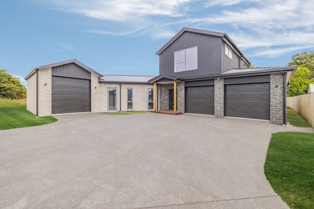 Front exterior — two-storey with triple garage and stone pillars
