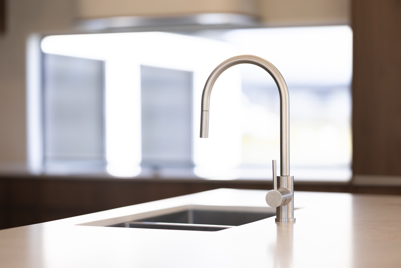 Stainless steel goose-neck mixer over undermount sink