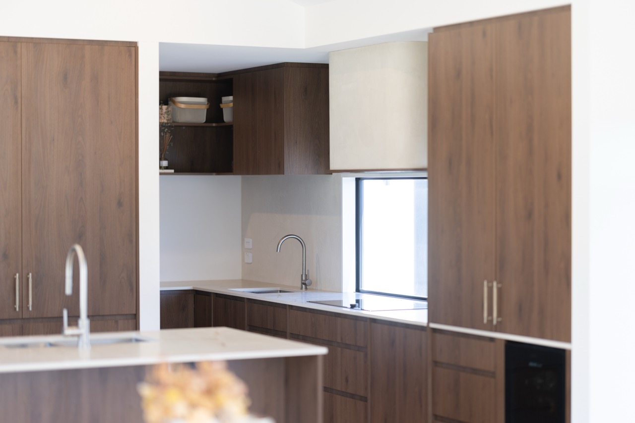 Walnut kitchen and scullery with stone benchtops and gas cooktop