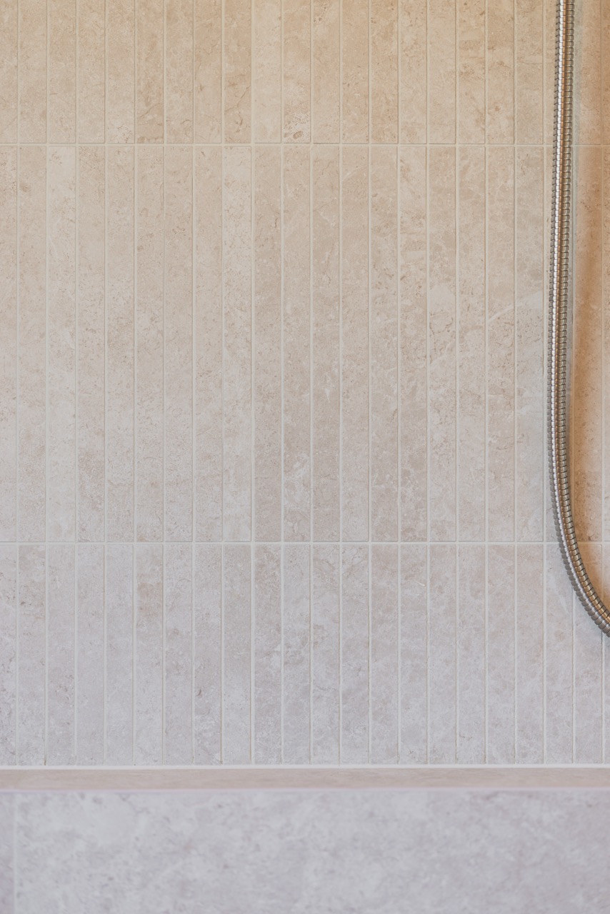 Vertical pencil tile detail — travertine and limestone tones
