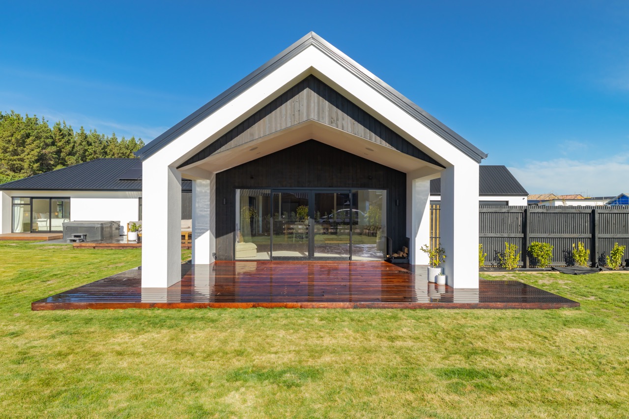 Rear elevation — pitched gable porch with hardwood deck and lawn